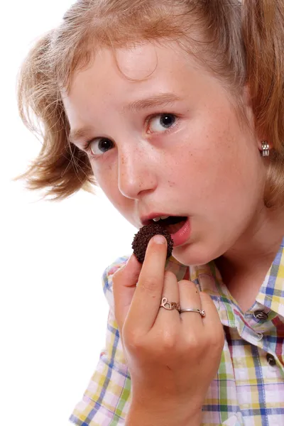 Jong meisje met chocolade snoep. — Stockfoto