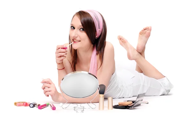 Adolescente chica haciendo maquillaje sobre un fondo blanco — Foto de Stock