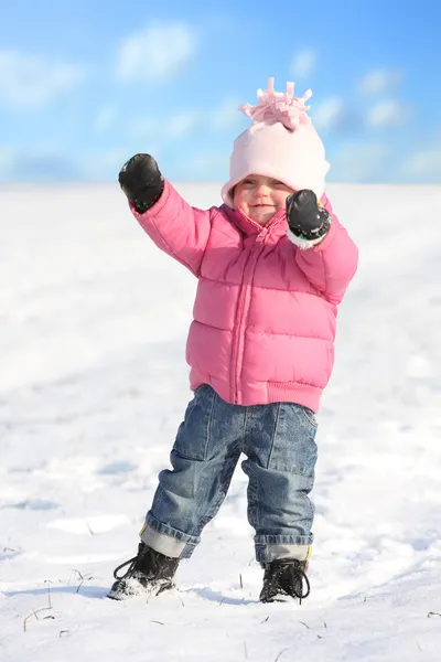 Happy little girl playing in a snowy landscape. — Stock Photo, Image