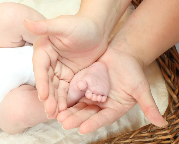 Baby nohy v rukou matky. — Stock fotografie