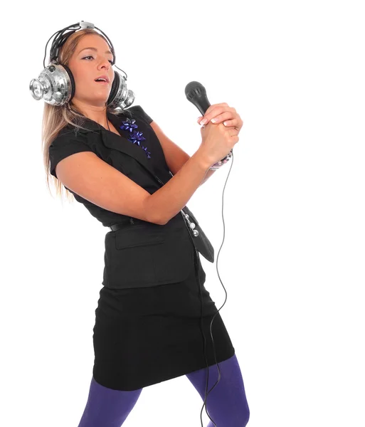Girl enjoys listening music in headphones, holding mic — Stock Photo, Image