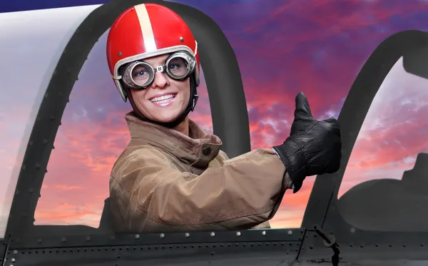 Beautiful girl in a cockpit of a vintage plane. Close up with shallow DOF. — Stock Photo, Image