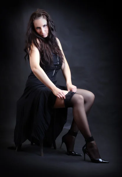 工作室拍摄剥绒黑色尼龙袜的年轻漂亮的女人 — 图库照片