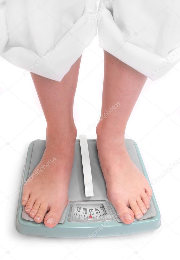 Young woman on a weighing machine.