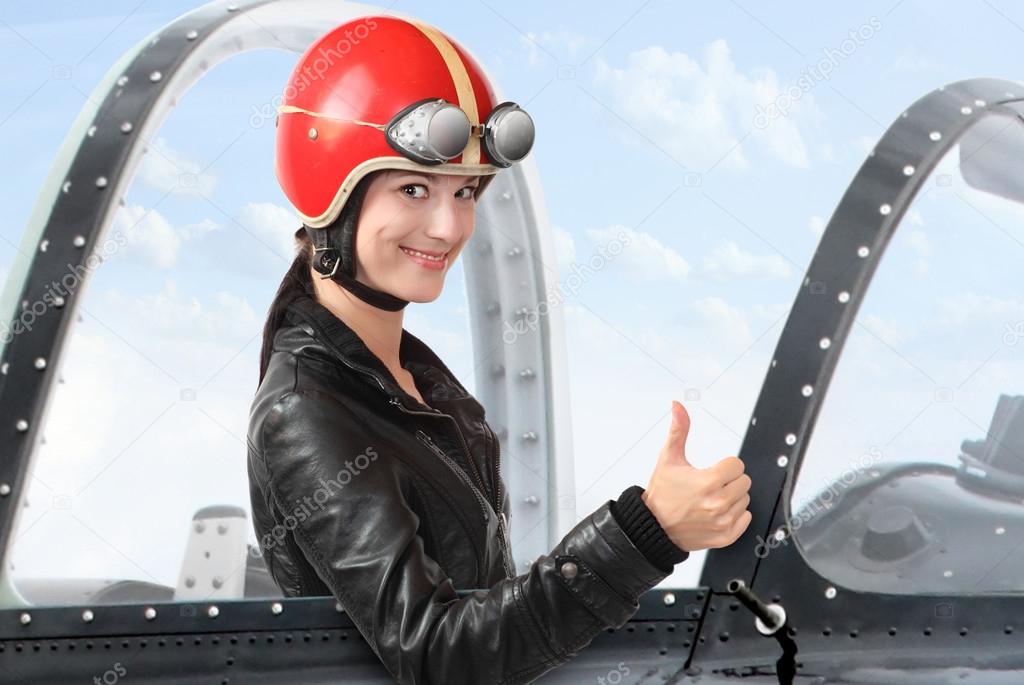 Beautiful girl in a cockpit of a vintage plane. Close up with shallow DOF.