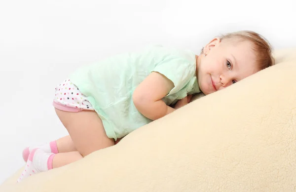 Little girl on a plushy blanket. — Stock Photo, Image