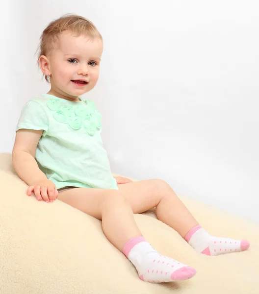 Little girl on a plushy blanket. — Stock Photo, Image