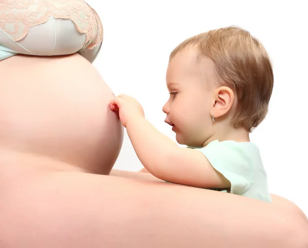 Klein meisje en haar zwangere moeder. gelukkig familie concept. — Stockfoto