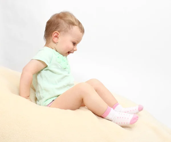 Little girl on a plushy blanket. — Stock Photo, Image