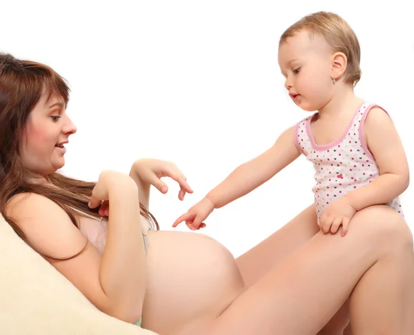 Klein meisje en haar zwangere moeder. gelukkig familie concept. — Stockfoto