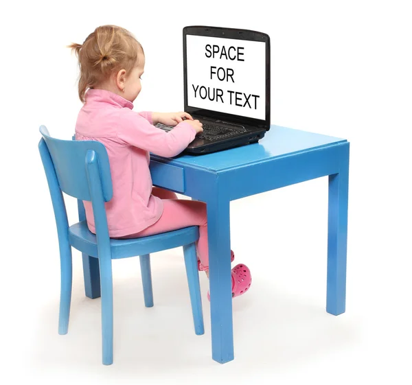 Pequeno estudioso em uma mesa da escola com laptop . — Fotografia de Stock