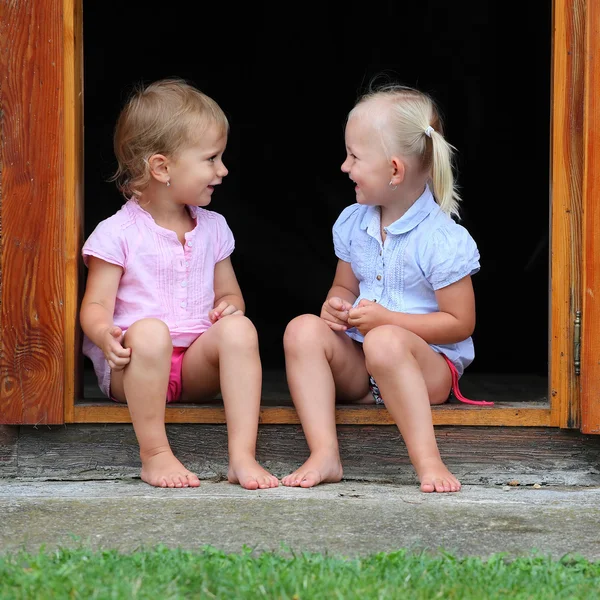 Grappige kinderen in de deuropening aan een landelijk huis. — Stockfoto