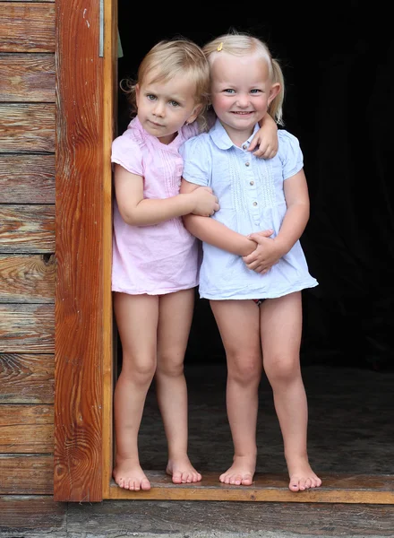 Des enfants drôles à la porte d'une maison rurale . — Photo