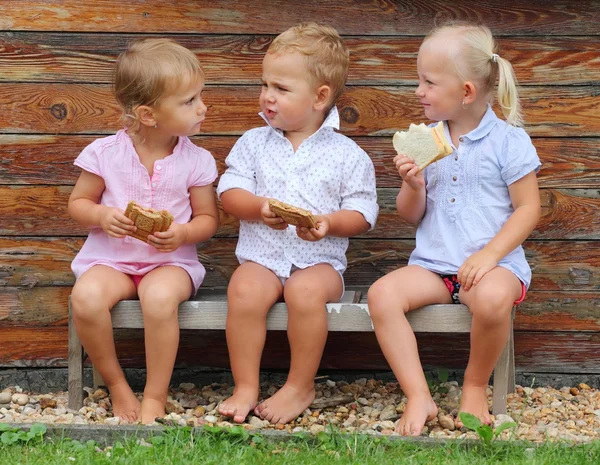 Bambini che mangiano sulla panchina rurale . — Foto Stock