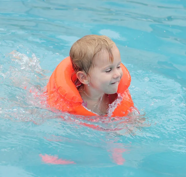 Маленький ребенок в спасательной куртке плавает. Концепция страхования . — стоковое фото