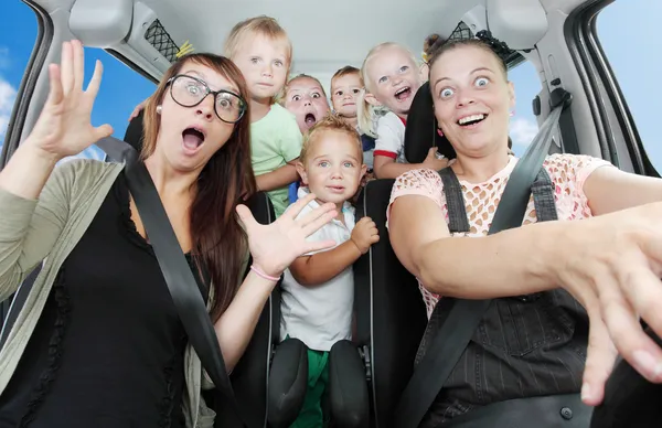 Crazy mothers with her children riding to holidays. — Stock Photo, Image