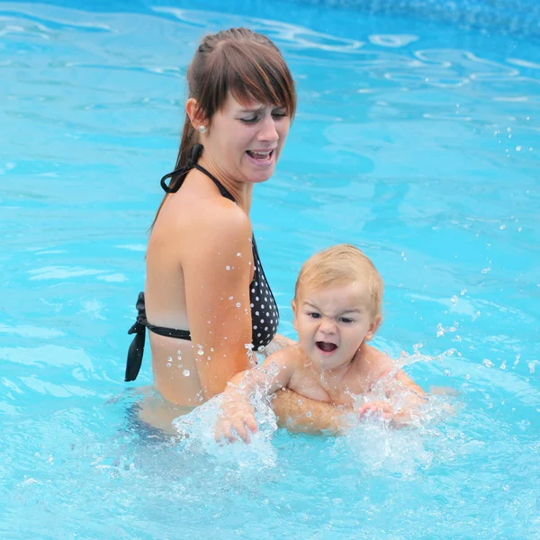 Молода мати зі своїм маленьким хлопчиком у басейні . — стокове фото