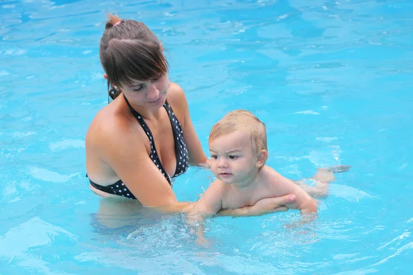 Ung mamma med hennes pojke i poolen. — Stockfoto