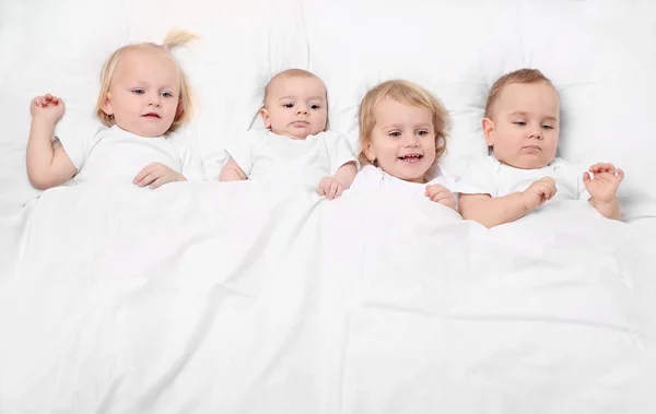 Hermanos pequeños en la cama. Concepto de familia feliz . —  Fotos de Stock