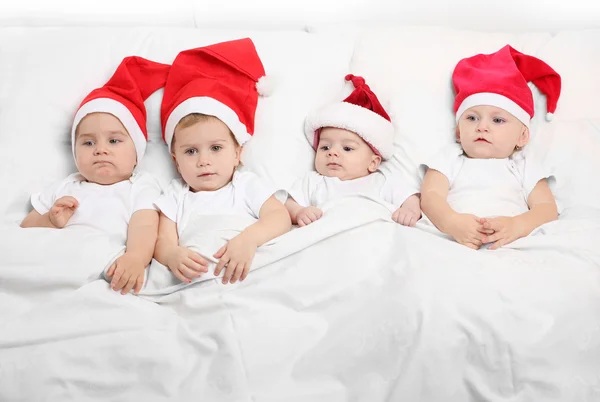 Küçük çocuklar üzerinde santa claus bekleyen yatakta. — Stok fotoğraf