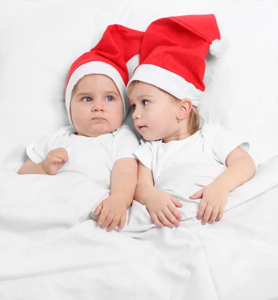 Niños pequeños en la cama esperando en Santa Claus . —  Fotos de Stock