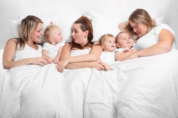 Mulheres e crianças conversando na cama — Fotografia de Stock