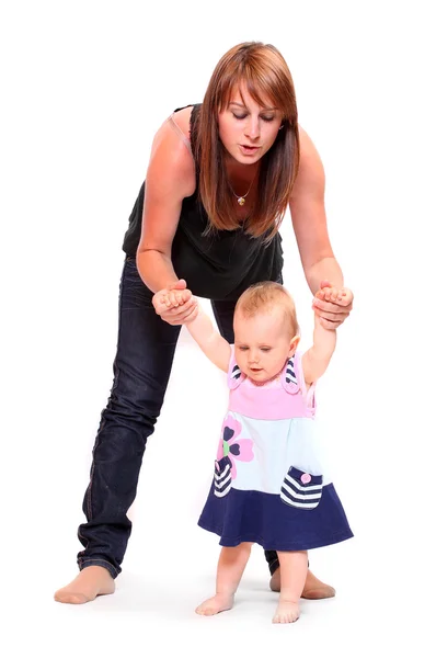 Baby doen van haar eerste stappen met moeder hulp. — Stockfoto