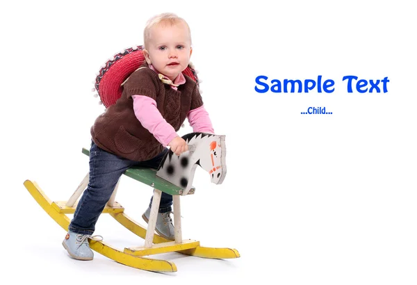 Niño feliz en un caballo mecedora con espacio para su texto . — Foto de Stock