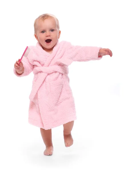 Criança feliz vestida com roupão de banho com escova de cabelo . — Fotografia de Stock