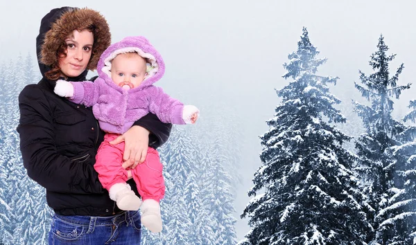 Jeune montagneuse avec son bébé vêtue d'une fourrure dans les montagnes enneigées. Saisonnière fashion shot . — Photo