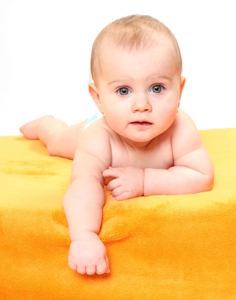 Şirin Bebek turuncu bir havlu üzerinde yalan. — Stok fotoğraf