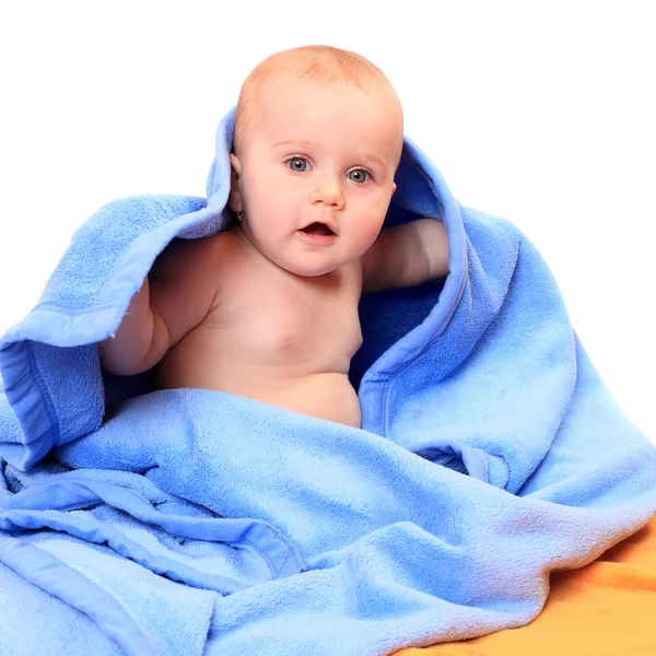 Bebê bonito sentado na toalha azul . — Fotografia de Stock