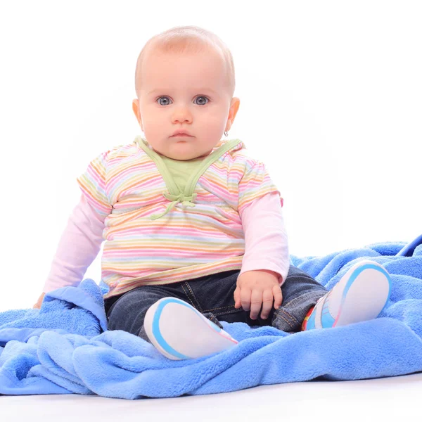 Niedliches Baby sitzt auf blauem Handtuch. — Stockfoto