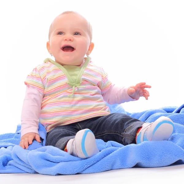 Bebê bonito sentado na toalha azul . — Fotografia de Stock