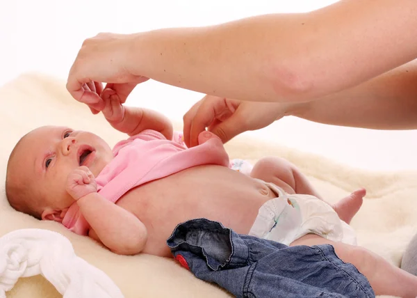 Junge Mutter zieht ihre Tochter an. — Stockfoto