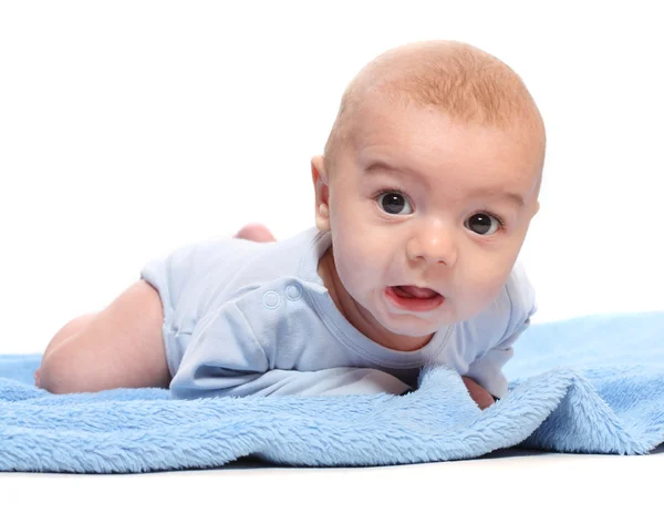 Imagem engraçada de um bebê bonito em uma toalha azul . — Fotografia de Stock