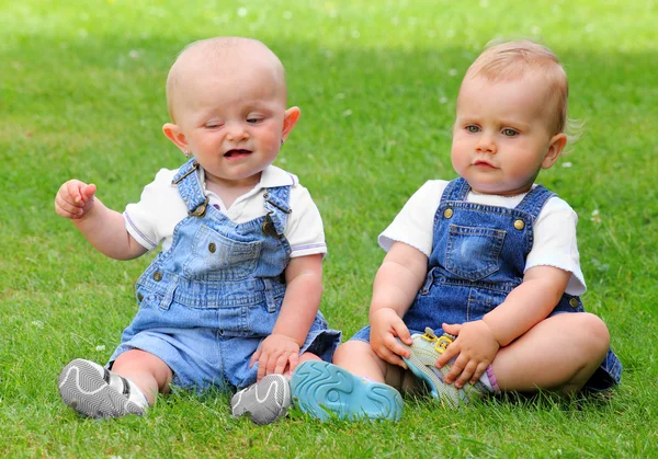 Due bambini parlanti sul prato verde . — Foto Stock