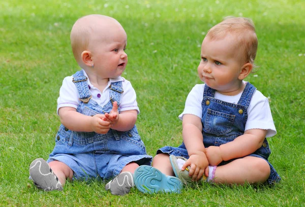 緑の牧草地に 2 人の話している子供. — ストック写真