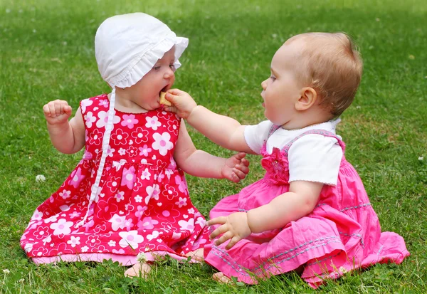 Deux petites sœurs assises sur une herbe . — Photo