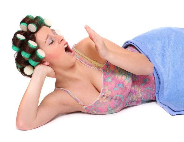 Yawning young woman with colorful hair-curlers — Stock Photo, Image