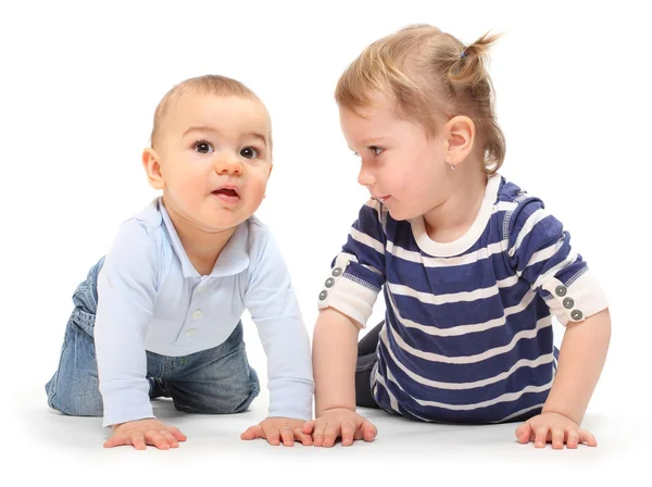 Playing children. An girl with her little brother on a white background. Stock Photo