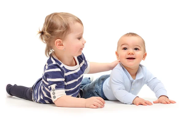 Playing children. An girl with her little brother on a white background. Stock Picture