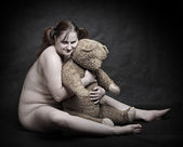 Studio shot overweight woman with old Teddy bear. Great for calendar.