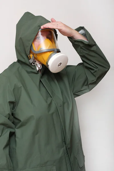 Žena nosí plynovou masku a ochranný oděv. — Stock fotografie