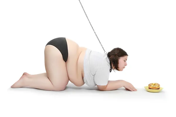 Funny picture of an hungry obese woman chained near plate with food. Diet concept. — Stock Photo, Image