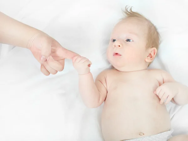 Newborn baby holding finger — Stock Photo, Image