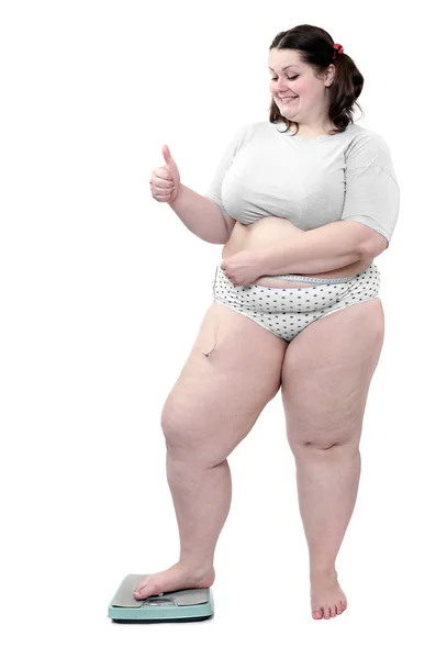 Glad överviktig kvinna mäta magen midja av meter-stick på en vägning maskin. — Stockfoto