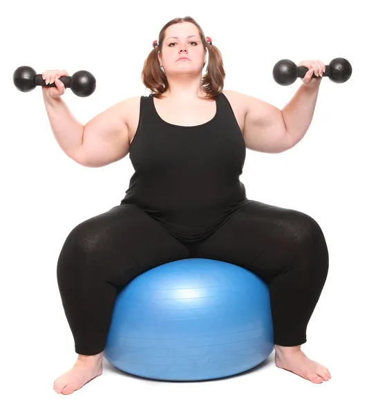 Tiro de una mujer joven con sobrepeso feliz con bola azul sobre un fondo blanco . — Foto de Stock