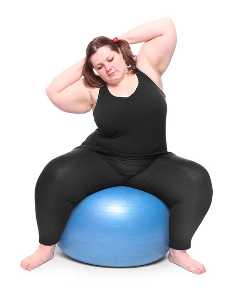 Tiro de una mujer joven con sobrepeso feliz con bola azul sobre un fondo blanco . — Foto de Stock