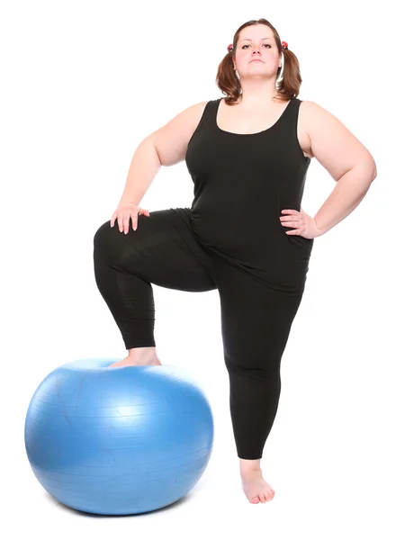 Aufnahme einer glücklichen übergewichtigen jungen Frau mit blauem Ball auf weißem Hintergrund. — Stockfoto
